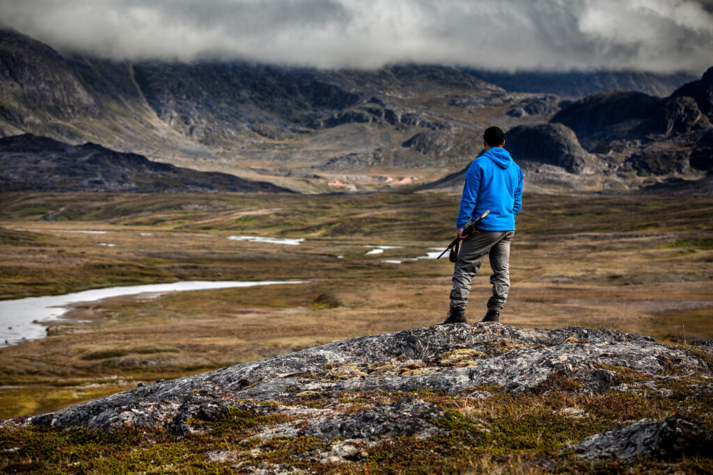 A hunter overlooking the river valley of Erfalik in Greenland