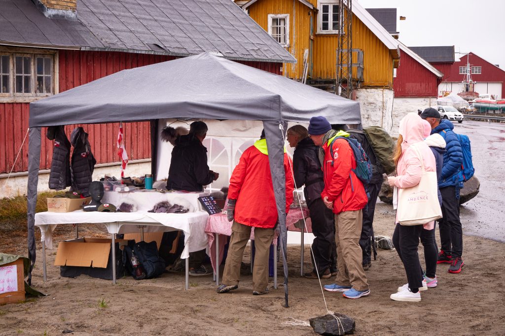 Cruise guests exploring items for sale in Sisimiut
